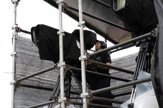 Concert video camera operator capturing an artist on stage